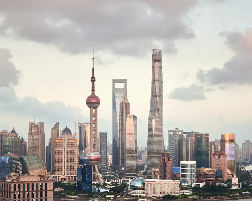 Bulutlu bir günde, Z Kuşağının yaşamak isteyebileceği modern bir şehir olarak Shanghai'nin Huangpu Nehri kıyısındaki ikonik Oriental Pearl Kulesi, Shanghai Kulesi ve diğer yüksek gökdelenlerden oluşan fütüristik silüeti göz alıcı bir şekilde uzanıyor.