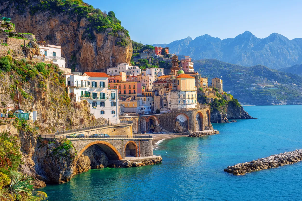İtalya’daki Amalfi Kıyıları’nda denize uzanan renkli evler ve kayalık sahil manzarası.