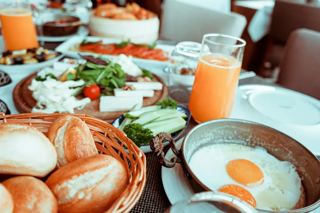 Taze sebzeler, peynir çeşitleri, yumurta ve portakal suyu ile sunulan zengin Türk serpme kahvaltı sofrası.