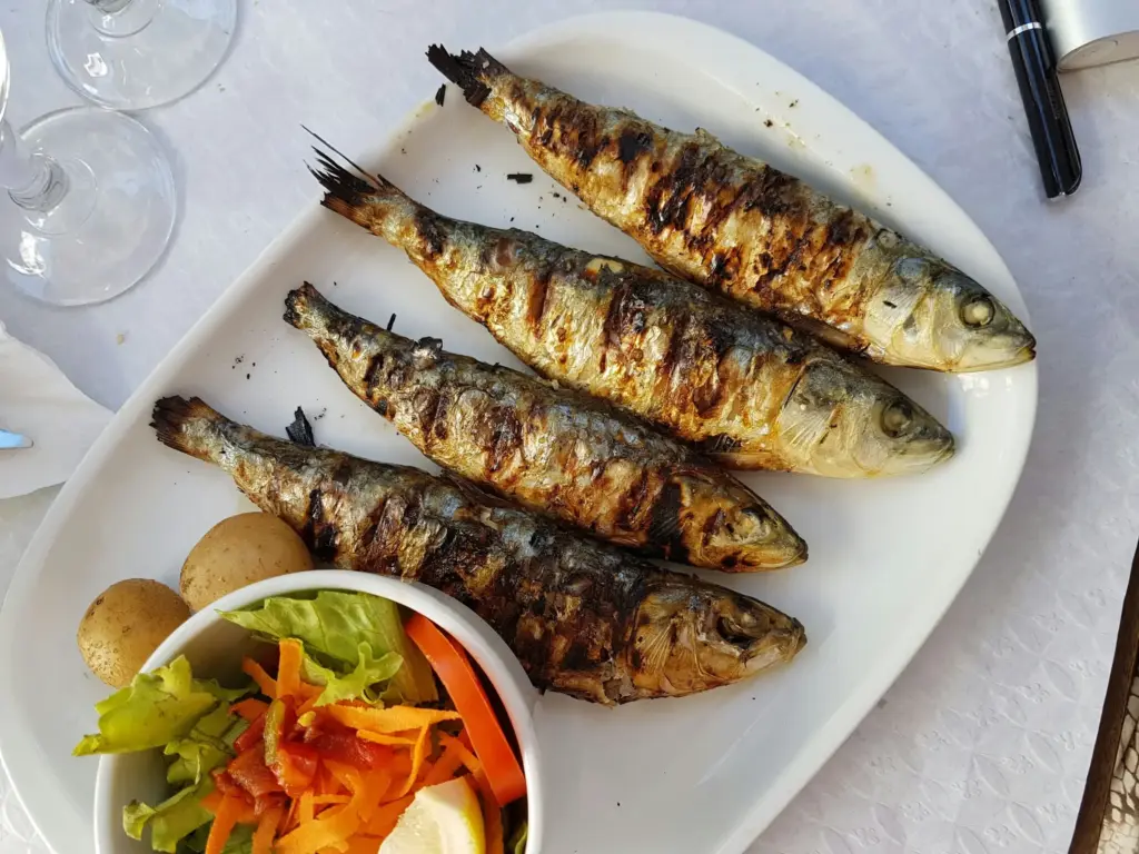 Izgara sardalya balığı ve haşlanmış patatesle servis edilen Akdeniz usulü deniz mahsulü tabağı