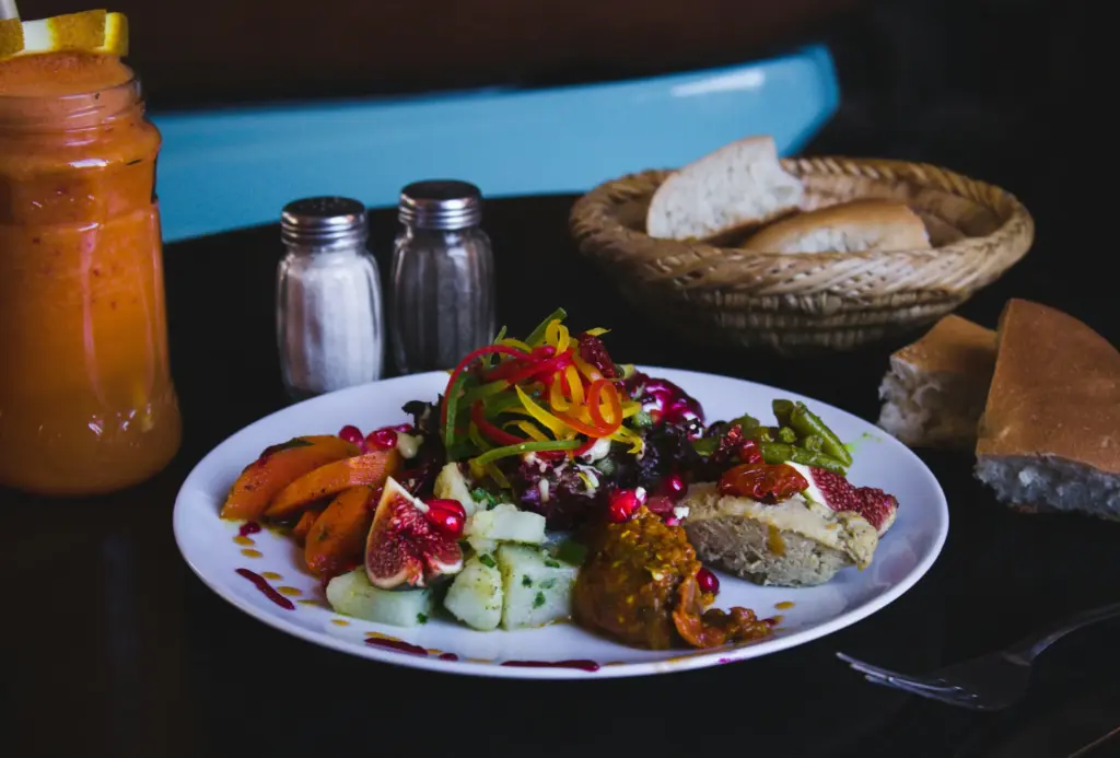 Renkli sebzeler, nar ve incirle süslenmiş zengin meze tabağı.