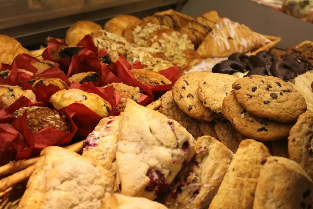 Pastanede sergilenen kurabiye, muffin ve kruvasanlardan oluşan tatlı tezgahı