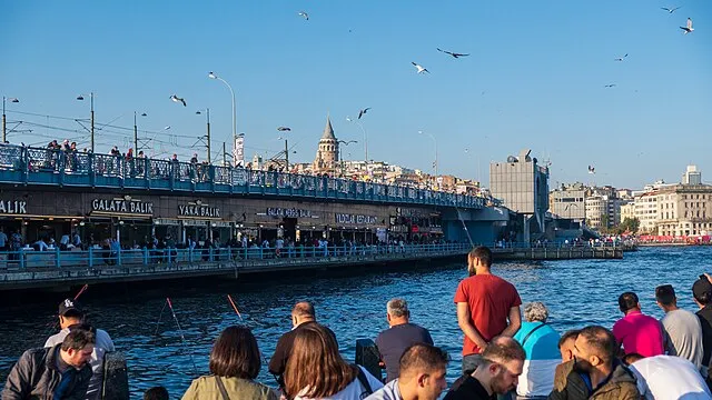 Galata Köprüsü ve çevresindeki restoranların yer aldığı hareketli Eminönü sahili; arka planda Galata Kulesi silueti ve balık tutan insanlarla birlikte canlı ve ikonik bir İstanbul manzarası.