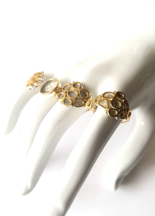 Beyaz manken el üzerinde sergilenen, sarı altın gövdeli ve damla formunda taşlarla bezeli üç farklı vintage yüzük modeli.