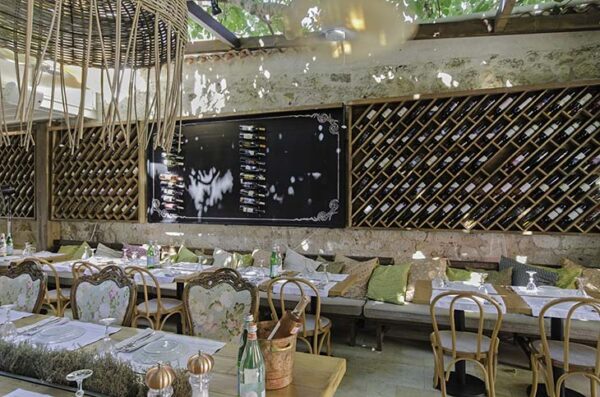 Alaçatı'da, tarihi dokusu korunmuş taş bir yapıda bulunan İnsula restoranının sarmaşıklarla gölgelenen açık hava oturma alanı, dolu şarap raflarıyla süslü duvarları, zarif çiçekli sandalyeleri ve minderlerle donatılmış banklarıyla samimi bir yemek deneyimi sunuyor.