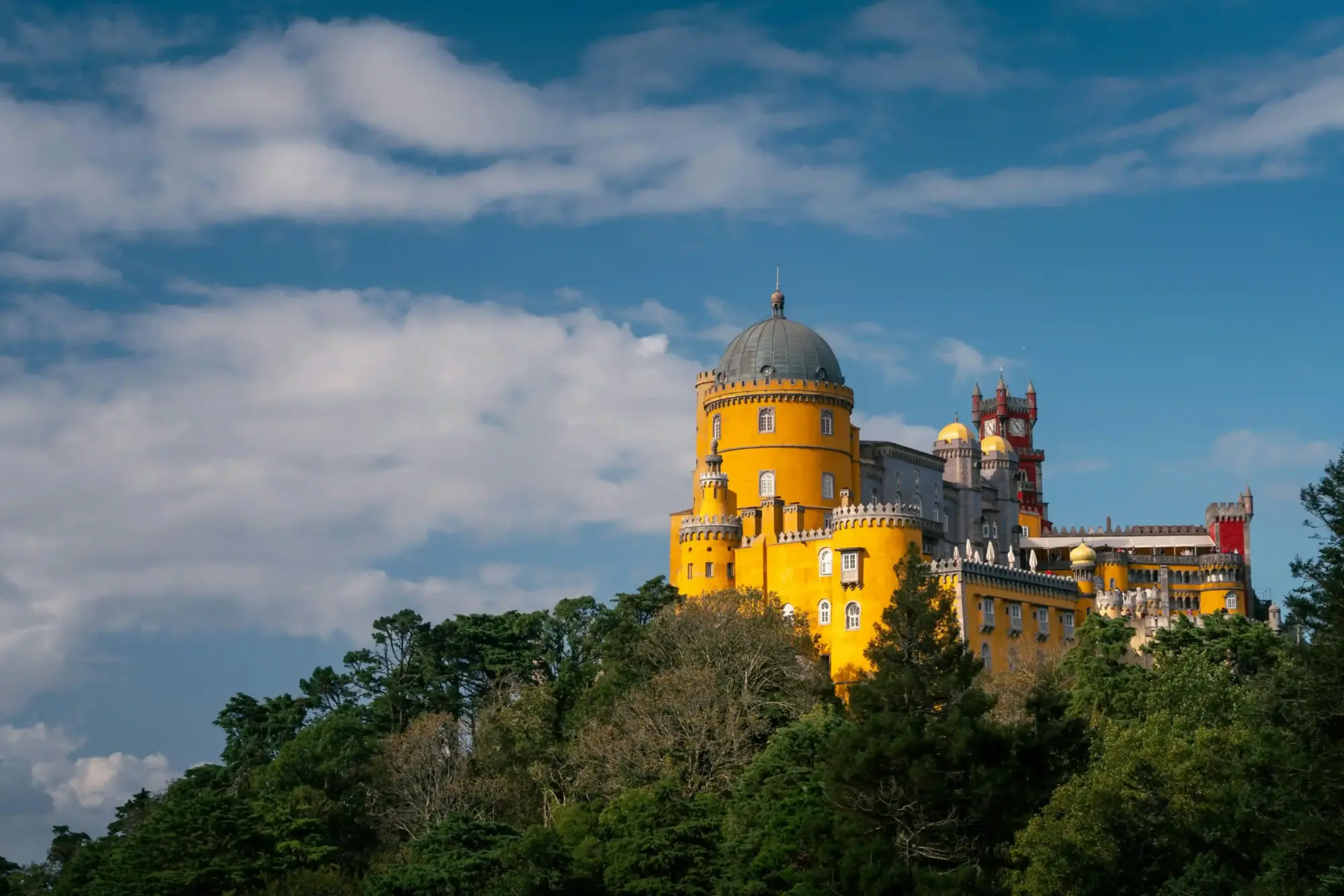 Sintra’daki Pena Sarayı’nın renkli cephesi ve romantik mimarisiyle tepeden görünümü