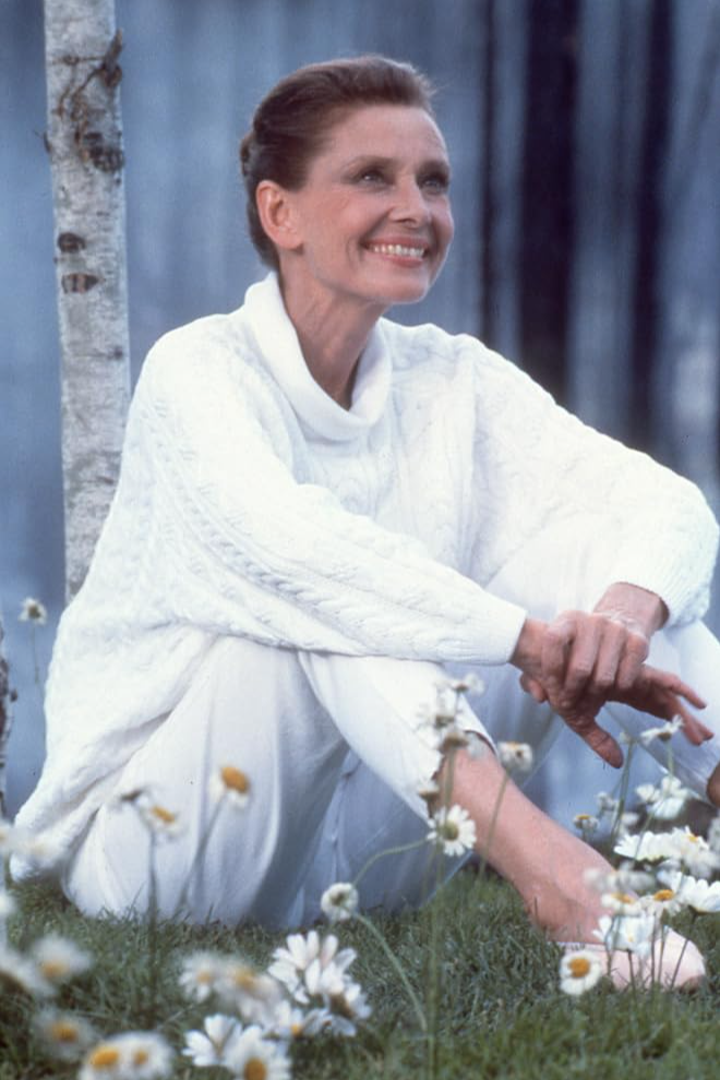 Beyaz kablo örgülü boğazlı kazağı ve pantolonuyla çimenlikte, etrafı papatyalarla çevrili bir ağacın dibinde huzurla oturmuş, hafifçe yukarı doğru gülümseyen Audrey Hepburn, kariyerinin son dönemine ait Always filmindeki unutulmaz bir anını canlandırıyor.