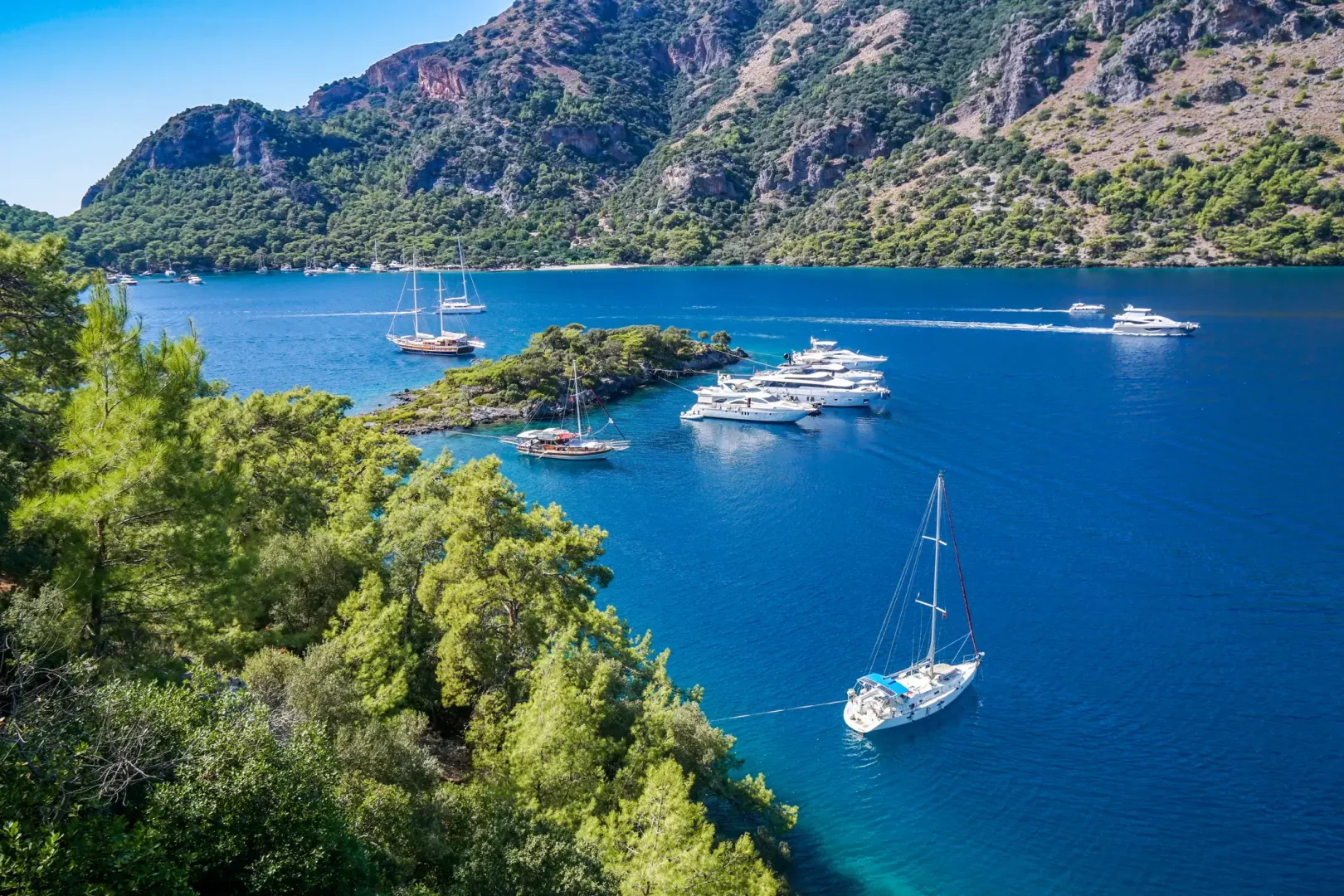Kerem Görsev'in deniz tutkusunu ve mavi yolculuklarını çağrıştıran bu eşsiz koyda, açık mavi, mavi ve lacivert tonlarının berraklığıyla parlayan denizde, yemyeşil ağaçlarla çevrili kıyılarda çok sayıda yelkenli ve motoryat demirlemiş olarak huzurlu bir manzara oluşturuyor.