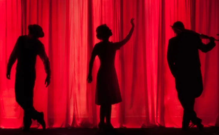Sahne arkasından kırmızı perdeler önünde görünen, çeşitli pozlarda üç oyuncunun teatral silüetleri; dramatik ve sanatsal bir atmosfer.