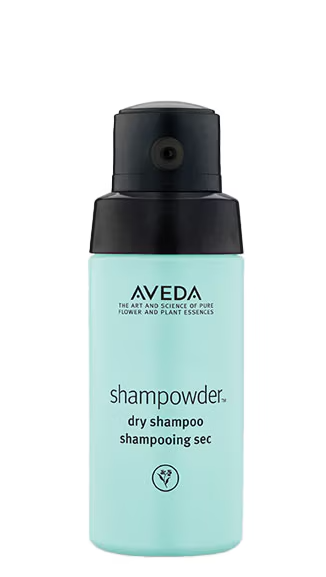 Açık camgöbeği rengindeki siyah kapaklı Aveda shampowder kuru şampuan şişesi, postta bahsedilen hacim veren özelliğiyle saçlara anında tazelik ve dolgunluk kazandıran doğal içerikli gazsız bir ürünü görselleştiriyor.