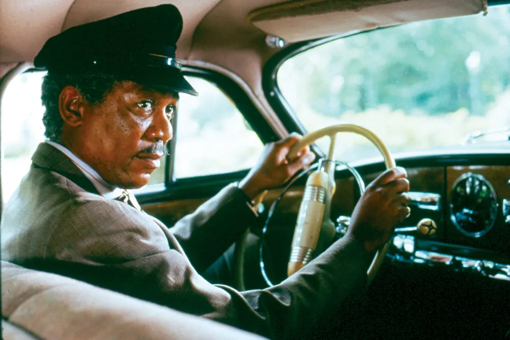 Morgan Freeman, Driving Miss Daisy filminde klasik arabada direksiyon başında, sade ama etkileyici bir karakterin ruhunu yansıtıyor.