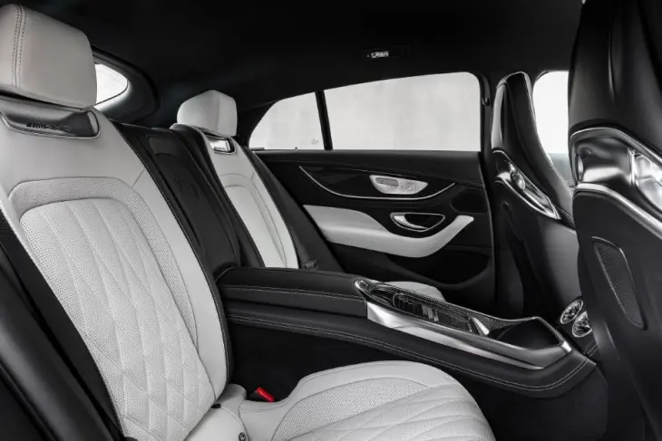 Mercedes-AMG GT 4 Kapı Coupe modelinin geniş ve lüks arka iç mekanı, beyaz dikişli ve kapitone desenli deri koltukları, sportif siyah ön koltuk arkalıkları ve iki yolcuya özel tasarlanmış merkezi konsolu ile dört kişilik oturma kapasitesini vurguluyor.