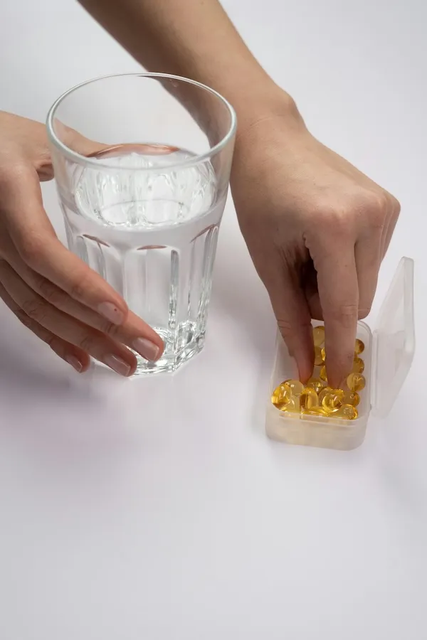 Kadının su ile omega 3 kapsülü alması, kadın sağlığı ve hormon dengesi için takviye kullanımı