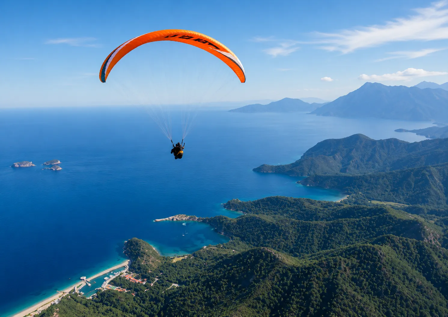 Masmavi denizin ve Tahtalı Dağı'nın yemyeşil ormanlarla kaplı eteklerinin üzerinde turuncu bir paragliding yapan sporcu, göz alıcı koyları ve adaları kapsayan panoramik bir manzaranın keyfini çıkarıyor.