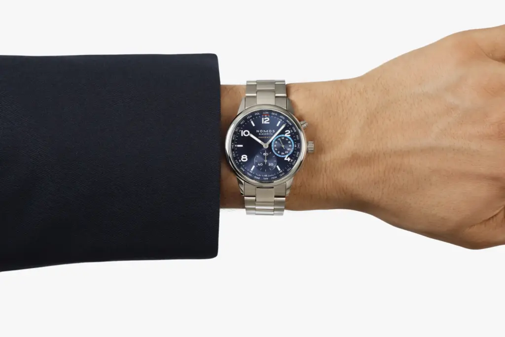 Nomos Glashütte Club Sport neomatik Worldtimer, paslanmaz çelik bilezikli, mavi kadranlı ve dünya saatleri komplikasyonlu otomatik saat.