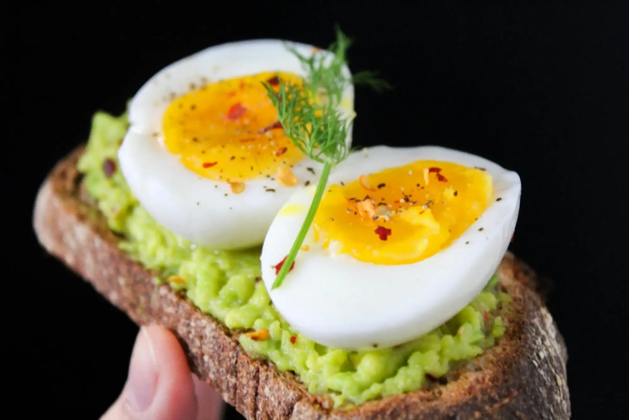 Avokado püresi üzerine yerleştirilmiş haşlanmış yumurta ve baharatlarla hazırlanan sağlıklı avokadolu tost close-up görünüm