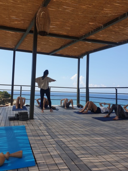 Denize karşı açık hava platformunda grup halinde yapılan hareket terapisi çalışması, katılımcıların matlar üzerinde uzandığı bir an.