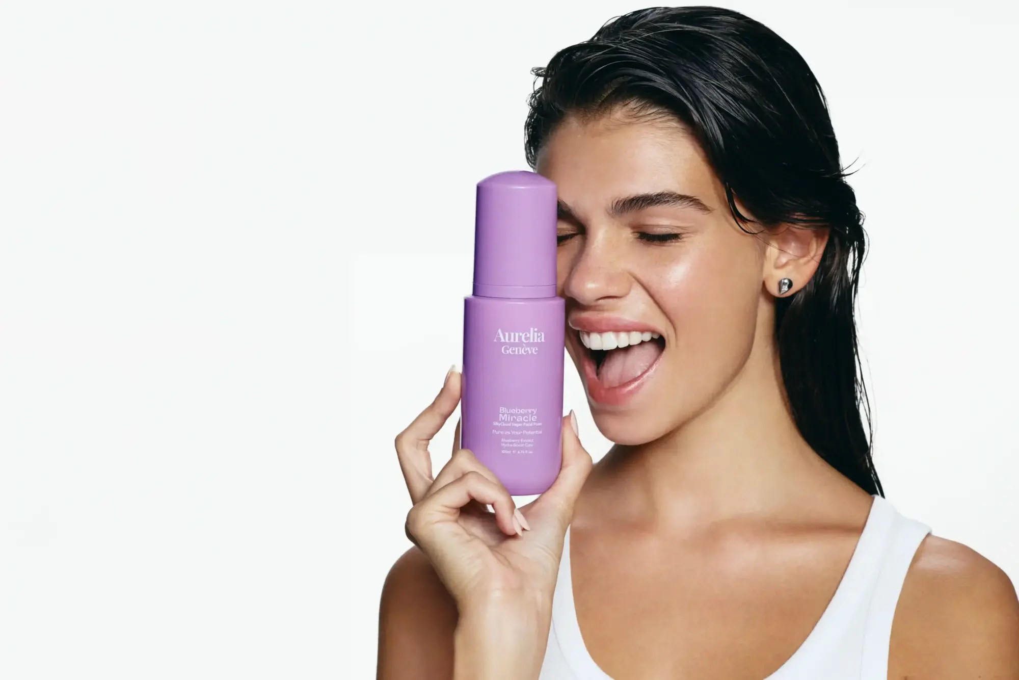 Aurelia Genève Blueberry Miracle cilt bakım ürünü, beyaz fonda model tarafından elde tutulurken.