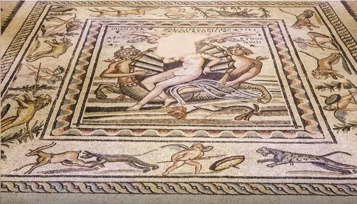 Antik bir Zeugma mozaiğinde, ortada başı eksik Venüs'ün deniz kabuğu üzerinde uzanarak tasvir edildiği, iki yanında balık kuyruklu mitolojik deniz tanrılarının yer aldığı, çevresinde ise ceylan, leopar, aslan gibi çeşitli hayvanların ve kanatlı Eros figürlerinin bulunduğu sanatsal bir sahne.
