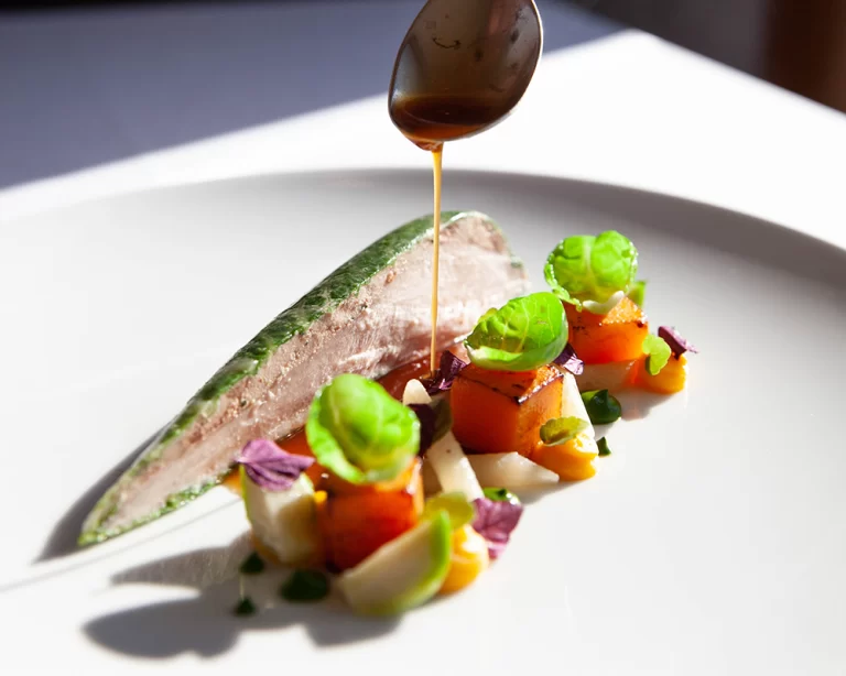 Michelin yıldızlı bir restoranda hazırlanan fine dining tabak; sos dökümüyle servis edilen şef dokunuşlu gastronomi sunumu.