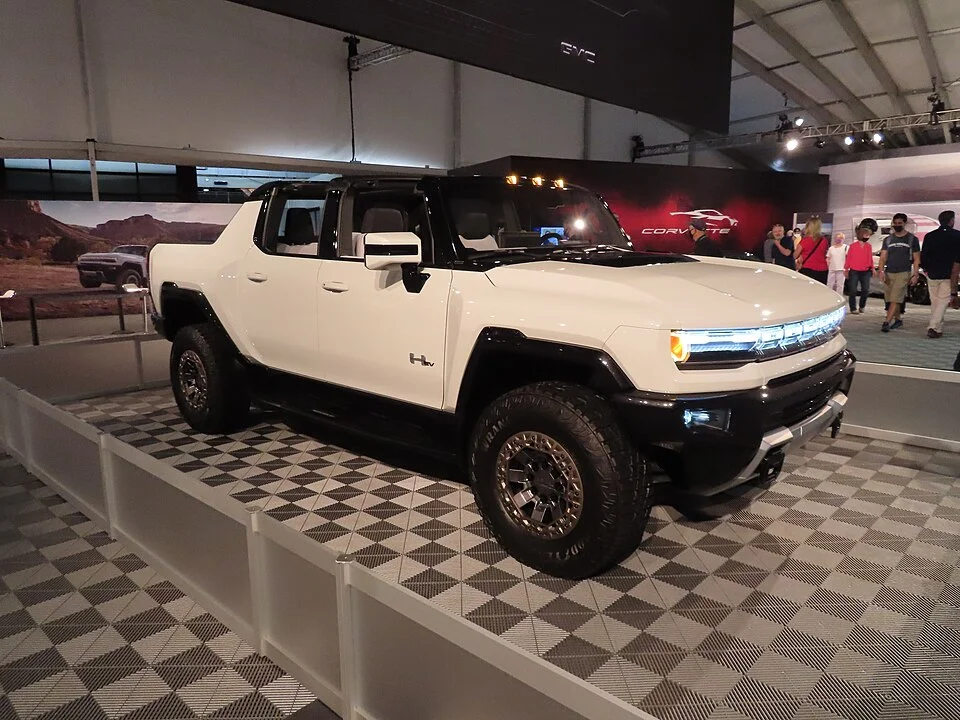 GMC Hummer EV, gücü ve yenilikçi tasarımı birleştiren, elektrikli bir pickup kamyon olarak, geniş tekerlekleri ve belirgin LED farlarıyla dikkat çekiyor, geleceğin lüks ve sürdürülebilir ulaşım çözümlerini temsil ediyor.