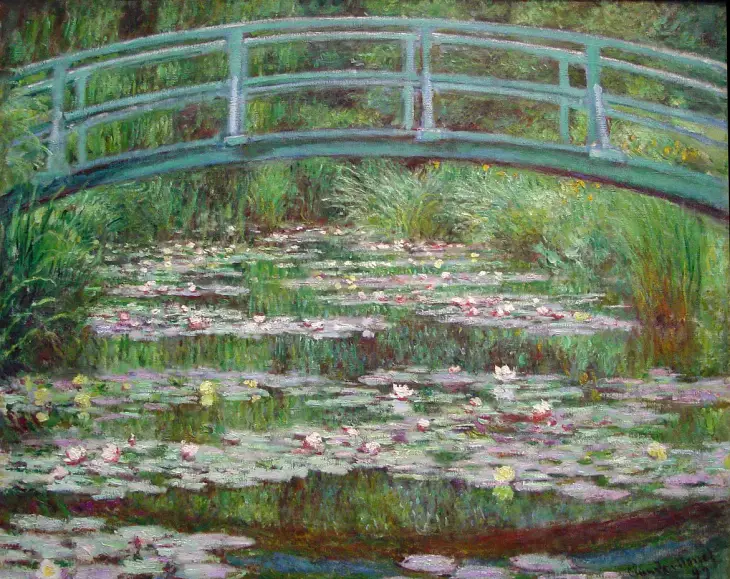 Claude Monet’nin Japon Köprüsü ve Nilüferler tablosu, bahçede yeşil kemer köprü ve su bitkileri.