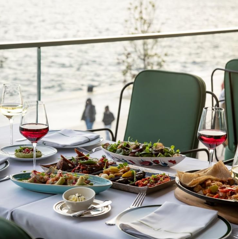 Galataport Liman İstanbul restoranında Boğaz manzaralı masada Türk mutfağından meze ve şarap servisi