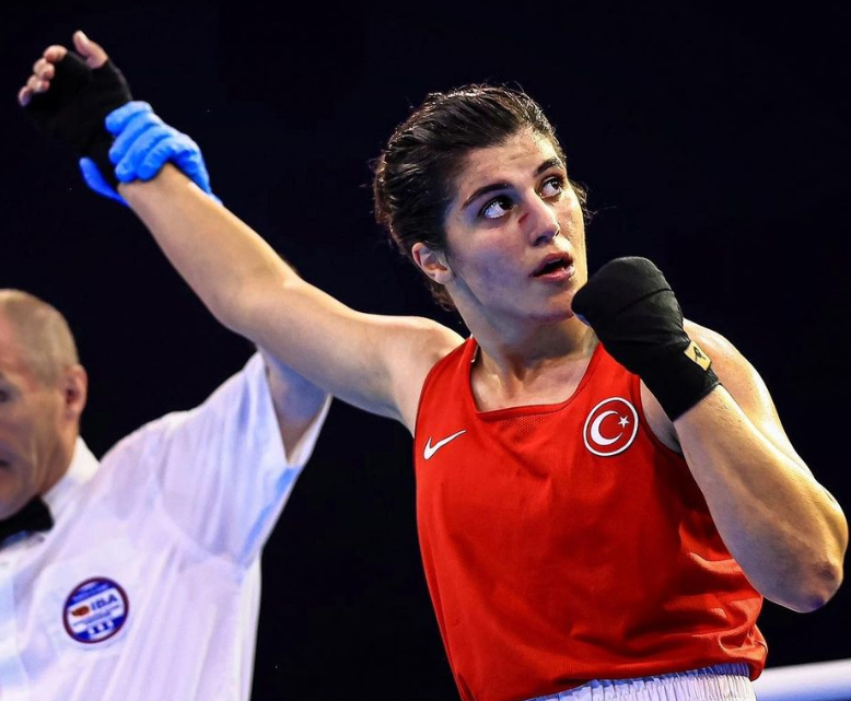 Türk milli boksör Busenaz Sürmeneli, ringde galibiyetini ilan ederken hakem tarafından eli kaldırılırken görüntüleniyor.