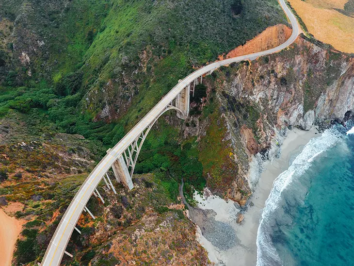 Pacific Coast Highway üzerinde yer alan ikonik Bixby Creek Köprüsü’nün havadan görünümü; Kaliforniya kıyısında motosiklet sürücüleri için en etkileyici manzaralardan biri.