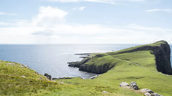 İskoçya’nın North Coast 500 rotasında yer alan yeşil tepeler ve deniz manzarası; Highlands bölgesinde motosiklet sürücüleri için unutulmaz bir sürüş noktası.