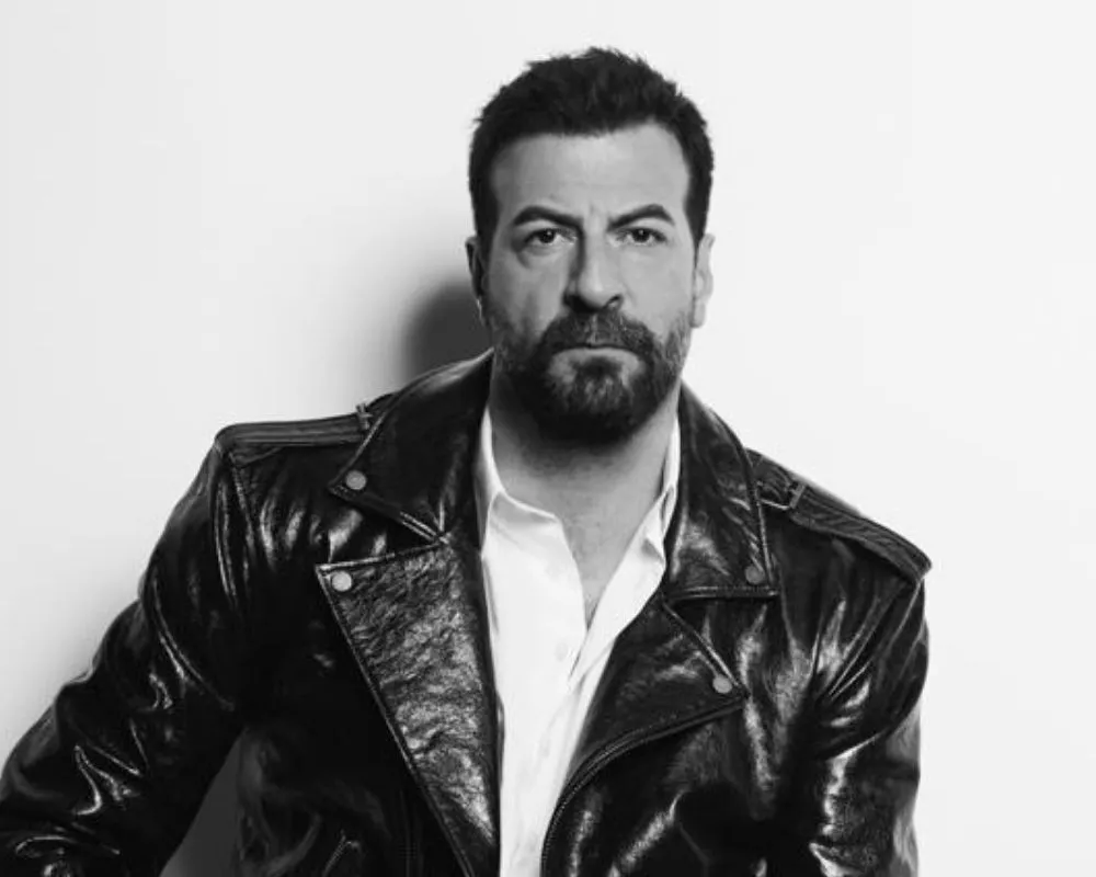 Aydınlık beyaz bir arka plan önünde çekilmiş siyah beyaz portre fotoğrafında, sakallı ve kısa koyu saçlı oyuncu İsmail Demirci, beyaz bir gömleğin üzerine giydiği parlak siyah deri ceketiyle ciddi bir ifadeyle doğrudan objektife bakıyor.