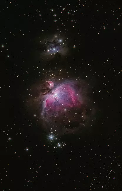 Karanlık uzay fonunda mor-pembe tonlarda parlayan Orion Bulutsusu.