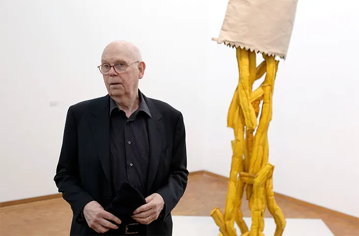 Pop Art akımının öncülerinden Claes Oldenburg, tüketim kültürünün simgesi haline gelen sıradan gündelik nesneleri dev boyutlarda yeniden yorumlayan sanatın en renkli başkaldırısı heykellerinden biri olan patates kızartması ve kağıt torba heykelinin yanında duruyor.