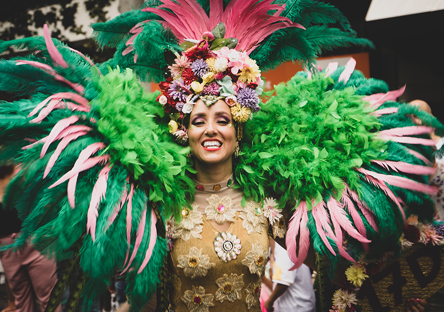 Rio Karnavalı’nda rengârenk tüy kostümüyle samba dansçısı, Brezilya kültürünü yansıtan gülümseyen kadın
