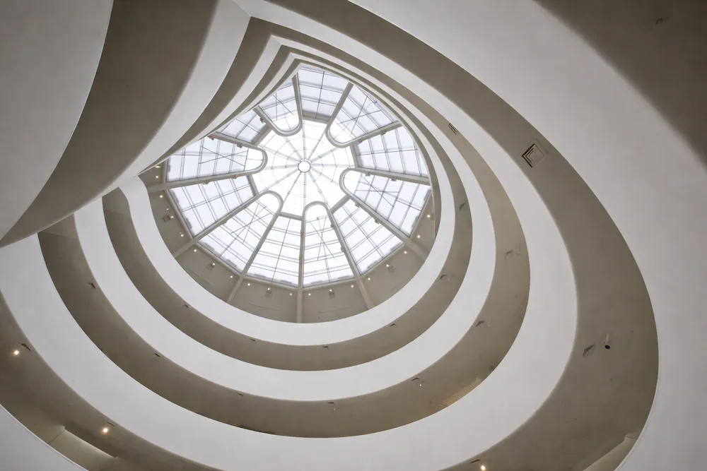Solomon R. Guggenheim Müzesi iç mekânında yer alan The Oculus (skylight), Frank Lloyd Wright tasarımı spiral mimari yapının merkezindeki cam kubbe; New York’taki ikonik modern müze atriumunda yukarıdan süzülen doğal ışık ve dairesel rampaların görünümü.