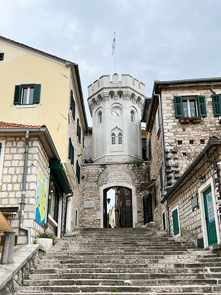 Herceg Novi'deki tarihi eski şehirde, yeşil panjurlu taş binaların çevrelediği geniş basamaklı merdivenlerin sonunda, tepesinde bayrak direği ve saat kadranı bulunan, mazgallı, silindirik görünümlü ünlü Saat Kulesi (Sahat Kula) yükseliyor ve ziyaretçileri Karadağ'ın bu güzel kıyı şehrinin dar sokaklarına davet ediyor.