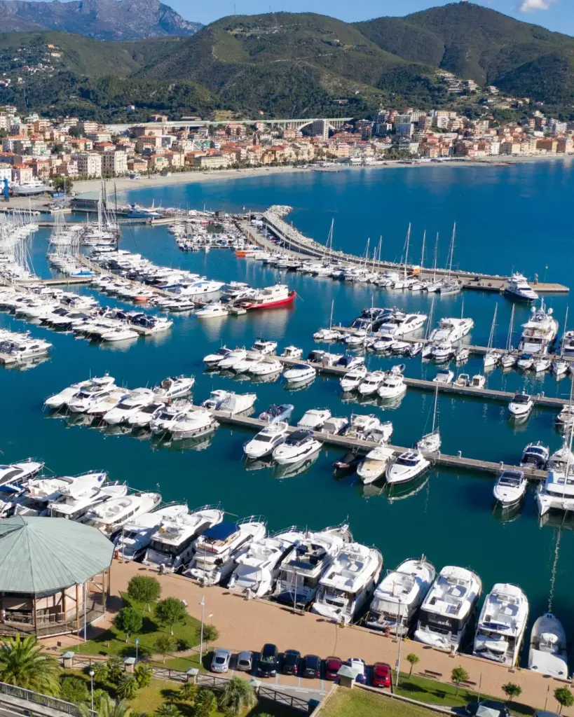 Mavi denizde sıralanmış sayısız lüks yat ve yelkenli teknenin bulunduğu, yemyeşil dağlarla çevrili bir sahil kasabasının önündeki canlı bir marinayı kuşbakışı gösteren bu fotoğraf, Türkiye'nin sunduğu en güzel marinaların cazibesini yansıtıyor.