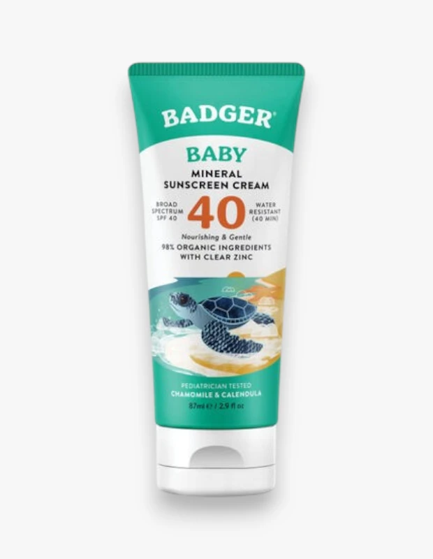 Badger Baby Mineral Güneş Kremi SPF 40 tüpü, bebeklerin hassas cildini güneşten korumak için geniş spektrumlu koruma, suya dayanıklılık, yüzde 98 organik bileşenler ve berrak çinko içerdiğini belirten metinlerle birlikte, ön yüzünde sevimli bir deniz kaplumbağası resmi taşıyor.