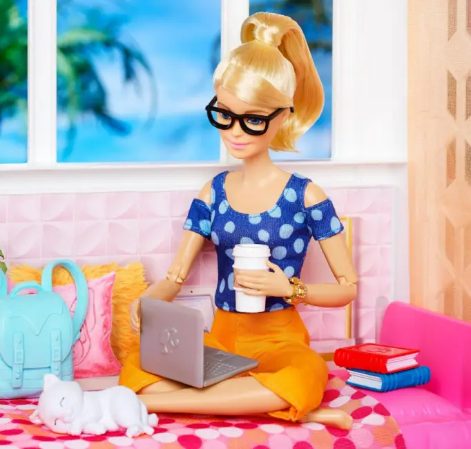 Gözlüklü, kahve içen ve dizüstü bilgisayar kullanan modern Barbie figürü; evde çalışan, teknolojiyle iç içe Barbie temsili