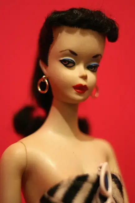 Orijinal Barbie bebeğin yakın plan portresi; keskin eyeliner, kırmızı ruj ve vintage saç stiliyle