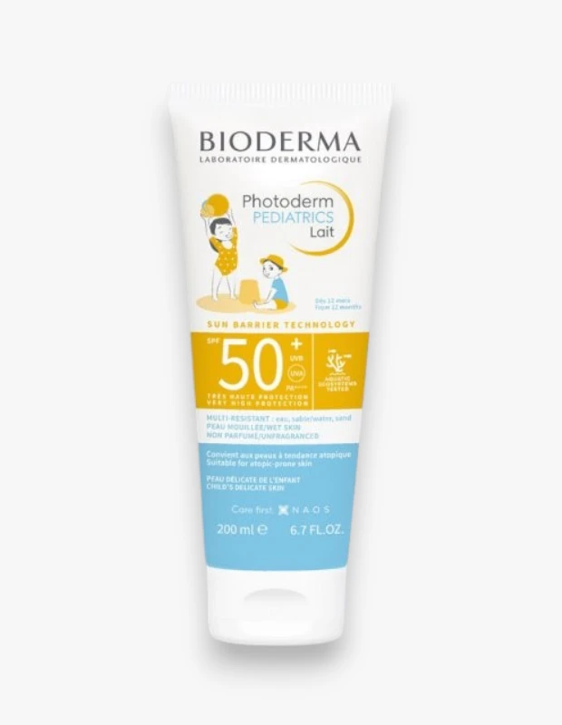 Bioderma Photoderm Pediatrics Lait SPF 50+ çocuk güneş kremi tüpü, üzerinde kumda oynayan çocuk illüstrasyonları bulunan, hassas ve atopik çocuk ciltleri için çok yüksek koruma sağlayan, suya, kuma dayanıklı ve parfümsüz bir üründür.