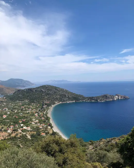 Datça rehberi içeriğine uygun olarak, Ege ile Akdeniz'in buluştuğu noktadaki Datça Yarımadası'nın yemyeşil tepeleri ve çam ağaçları arasına gizlenmiş, berrak turkuaz sularıyla ışıldayan Ovabükü koyunun uzun kavisli sahili boyunca uzanan şirin evlerin görüldüğü kuşbakışı bir manzara.
