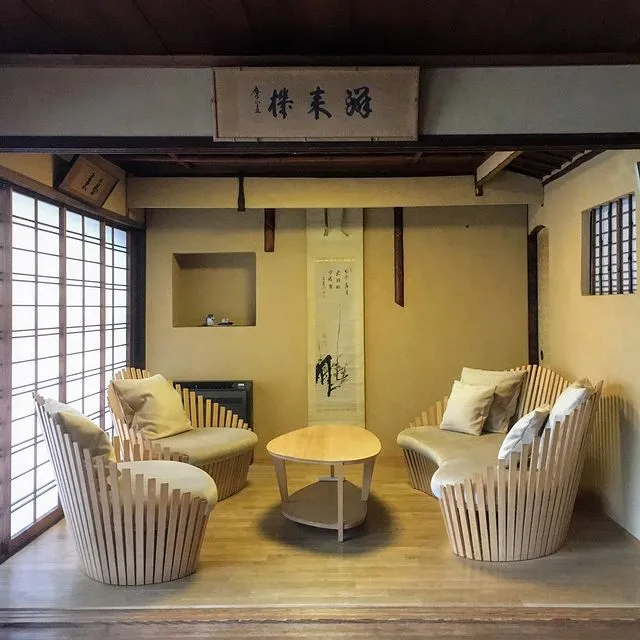 Kyoto'daki Izuyasu ryokanının geleneksel ahşap mimarisiyle harmanlanmış, modern çizgili mobilyalar ve dingin bir zen atmosferi sunan oturma alanı, Japonya'nın eşsiz balayı rotaları arasında lüks ve özgün bir deneyim vaat ediyor; en güzel balayı rotaları için ilham veren bir kare.