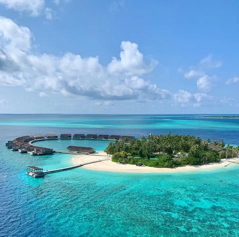 Kudadoo Maldives'in turkuaz sularında yer alan, palmiye ağaçlarıyla kaplı küçük bir ada, hilal şeklinde dizilmiş modern su üstü villaları ve uzun iskeleleriyle romantik balayı rotaları için lüks ve unutulmaz bir deneyim sunuyor; en güzel balayı rotaları için ilham veren bir kare.