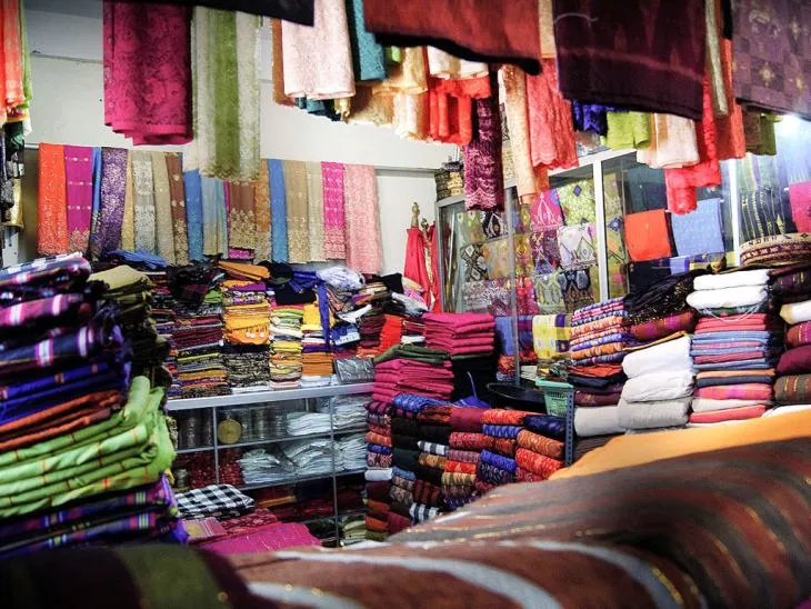 Bali pazarında sergilenen geleneksel Endek kumaşları, renkli tekstil ürünleri ve yerel üreticilerin el emeği dokumaları”
