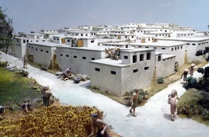 Çatalhöyük yerleşim alanı maketi, bitişik evler ve tarım yapan insanlar.