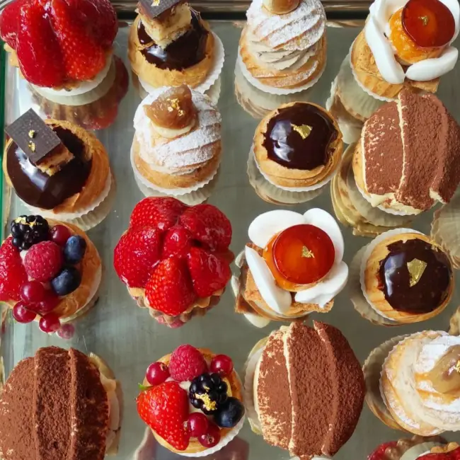 Cutie Cake pastanesinde vitrinde sergilenen Fransız pastacılığından ilham alan mini tatlılar; Saint Honoré, ekler, tiramisu ve meyveli tart çeşitleri.