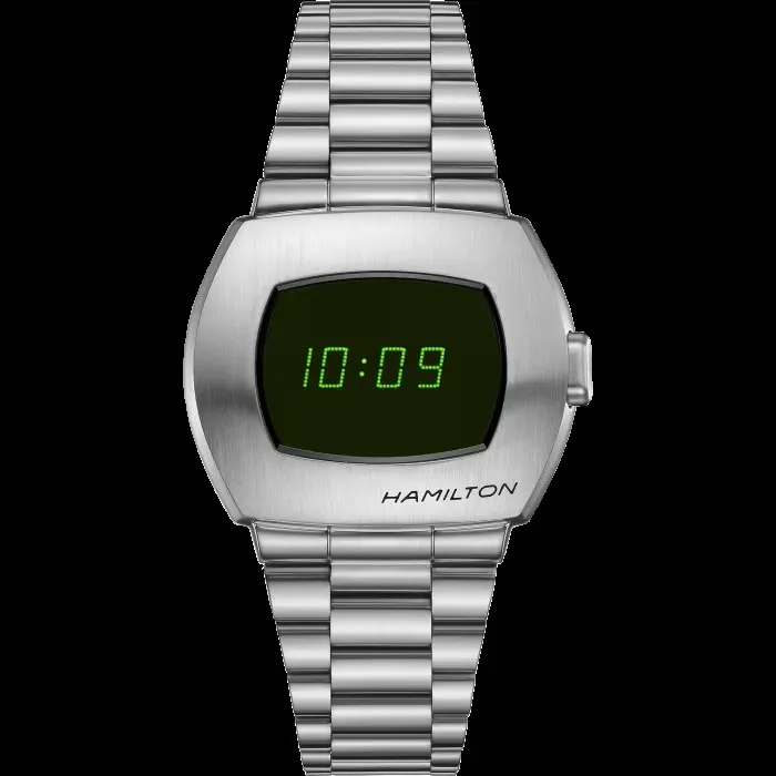 Parlak metal kasası, belirgin köşeli hatları ve karakteristik kırmızı LED dijital ekranıyla öne çıkan ikonik Hamilton Pulsar P2 saati, retro-fütüristik tasarım dilini ve zamansız çekiciliğini sergileyerek dijital saatlerin tarihsel önemini ve modern estetiğini net bir şekilde vurguluyor.