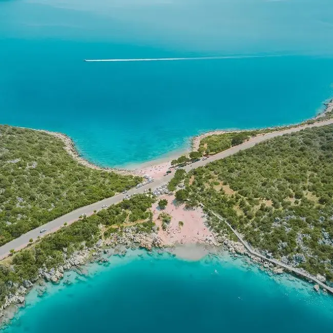 Antalya'nın en güzel plajlarından İnceboğaz Plajı'nın havadan çekilmiş bu görüntüsünde, ortasından yol geçen dar bir kara parçasının iki yanında uzanan sığ kumsallarda denizin keyfini çıkaran insanlarla çevrili kristal mavisi sular dikkat çekiyor.