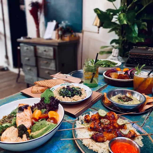Kavanoz İstanbul’un Akdeniz esintili menüsünden tabaklar; somonlu bowl, şiş tavuk, kinoa salatası ve ev yapımı limonatalarla sıcak bir bistro atmosferi.